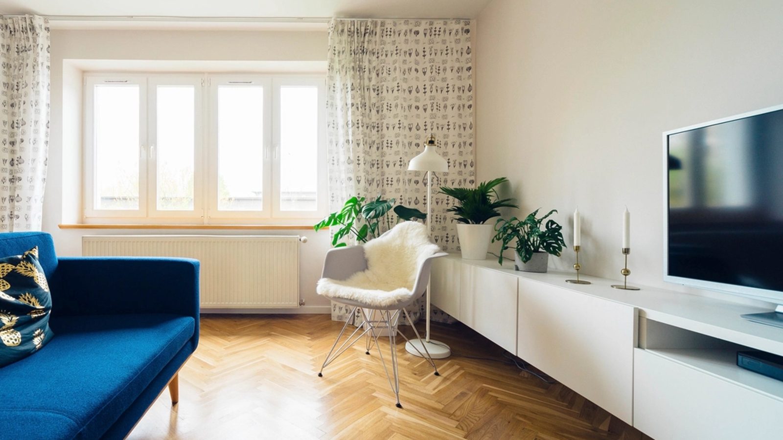 Salon avec televiseur et sofa bleu